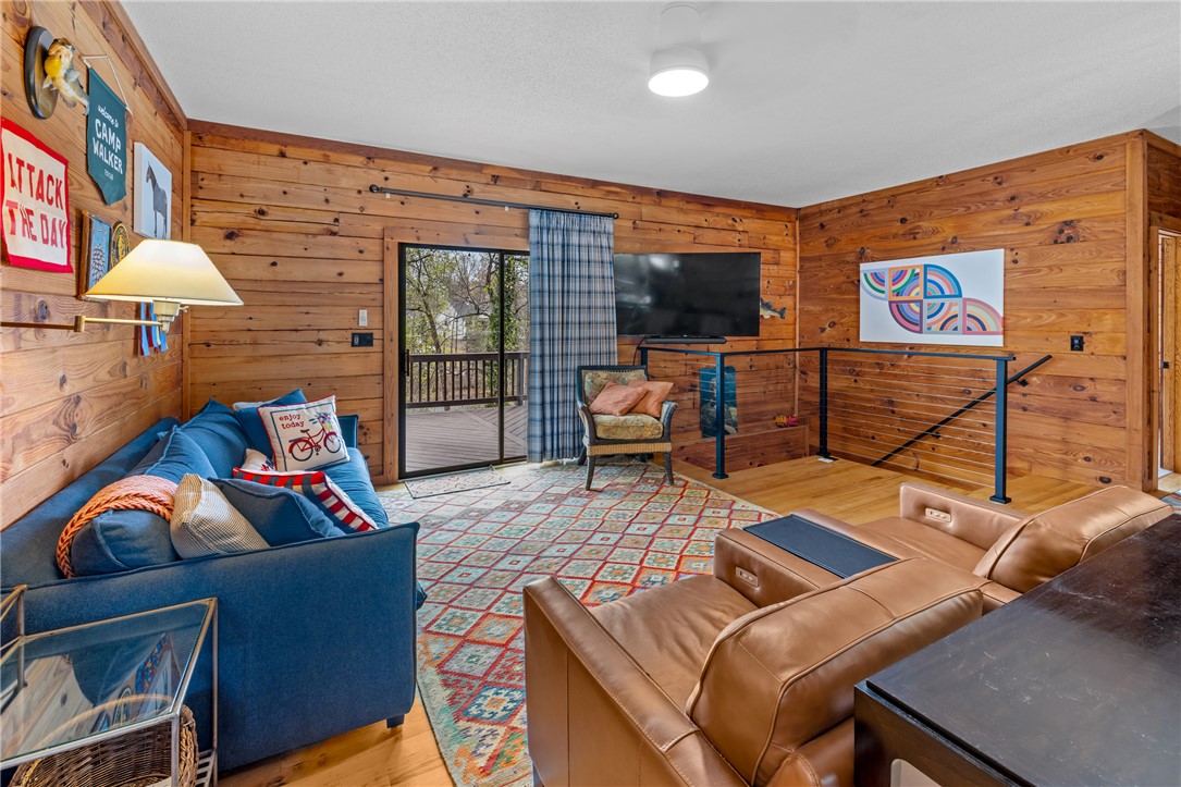 203 Little Lane Seneca, SC 29672 - Photo 14 of 48 This inviting living area boasts rich wood paneling, offering warmth and direct access to an outdoor deck.
