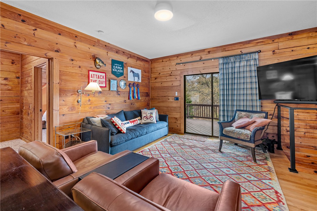 203 Little Lane Seneca, SC 29672 - Photo 15 of 48 This living room features rich wood paneling, an inviting deck access, and durable hardwood flooring.