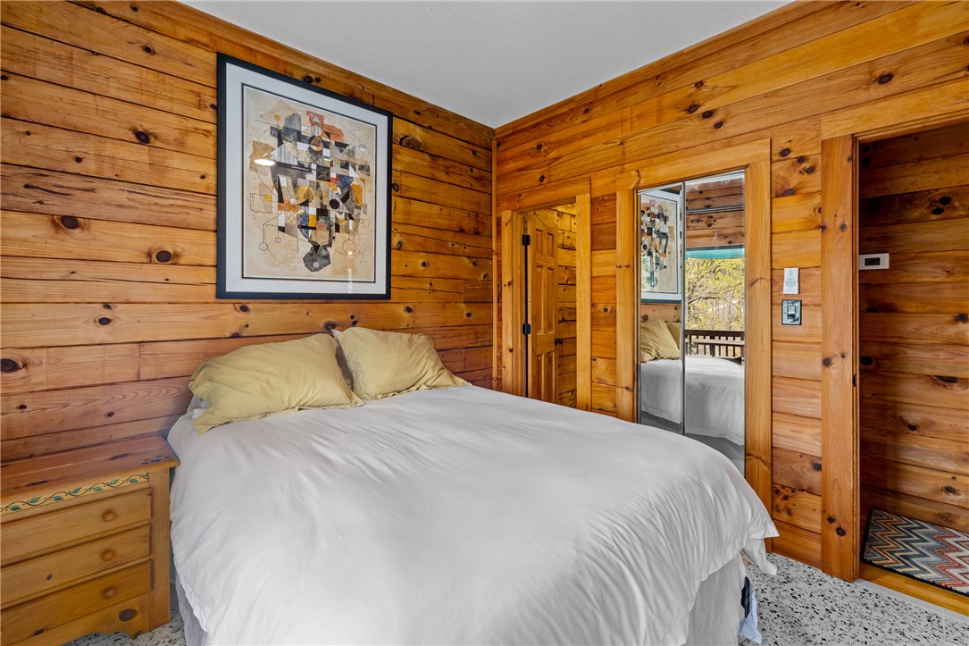 203 Little Lane Seneca, SC 29672 - Photo 23 of 48 This cozy bedroom features warm wood paneling, creating a rustic and inviting atmosphere.