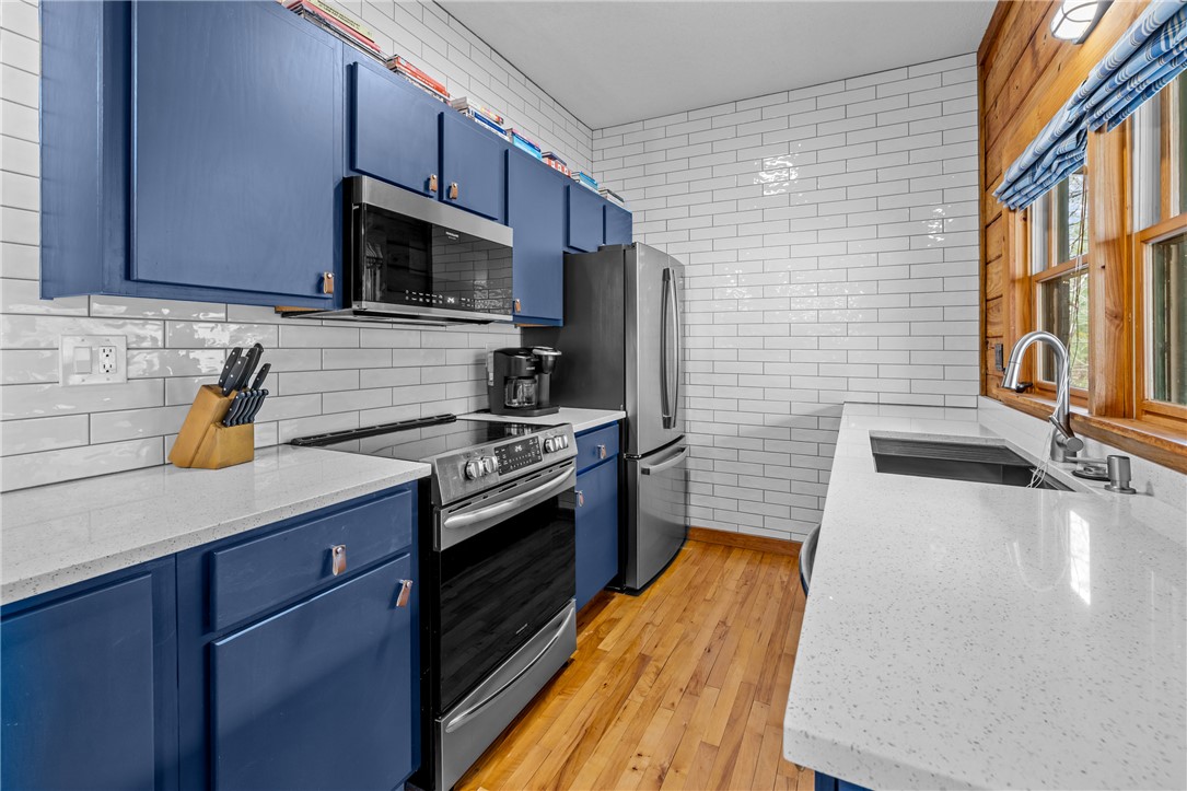 203 Little Lane Seneca, SC 29672 - Photo 9 of 48 This modern kitchen features crisp white countertops and a vibrant blue cabinetry, perfect for culinary endeavors.