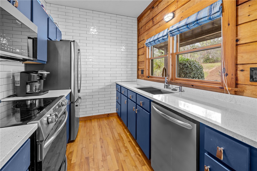 203 Little Lane Seneca, SC 29672 - Photo 10 of 48 This modern kitchen features bright countertops and classic wood flooring.