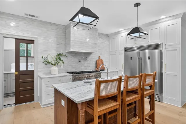 a kitchen with granite countertop a sink stainless steel appliances and cabinets