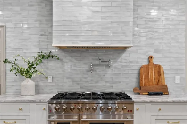 a kitchen with stainless steel appliances granite countertop a stove a kitchen island a dining table and chairs with wooden floor