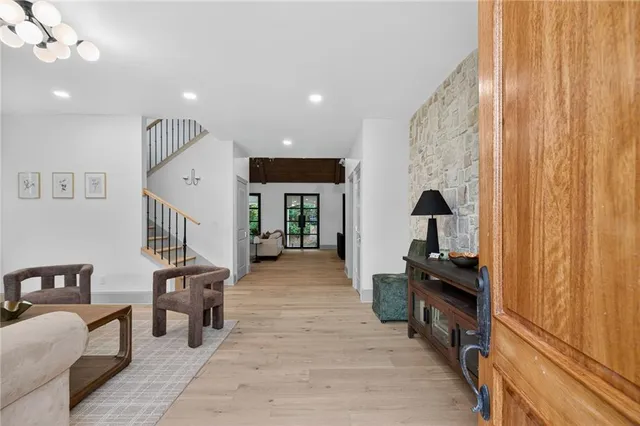 a living room with furniture a flat screen tv and a refrigerator