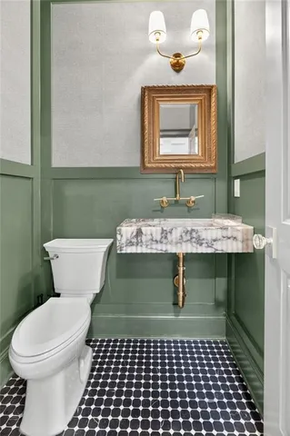 a bathroom with a sink a toilet and mirror