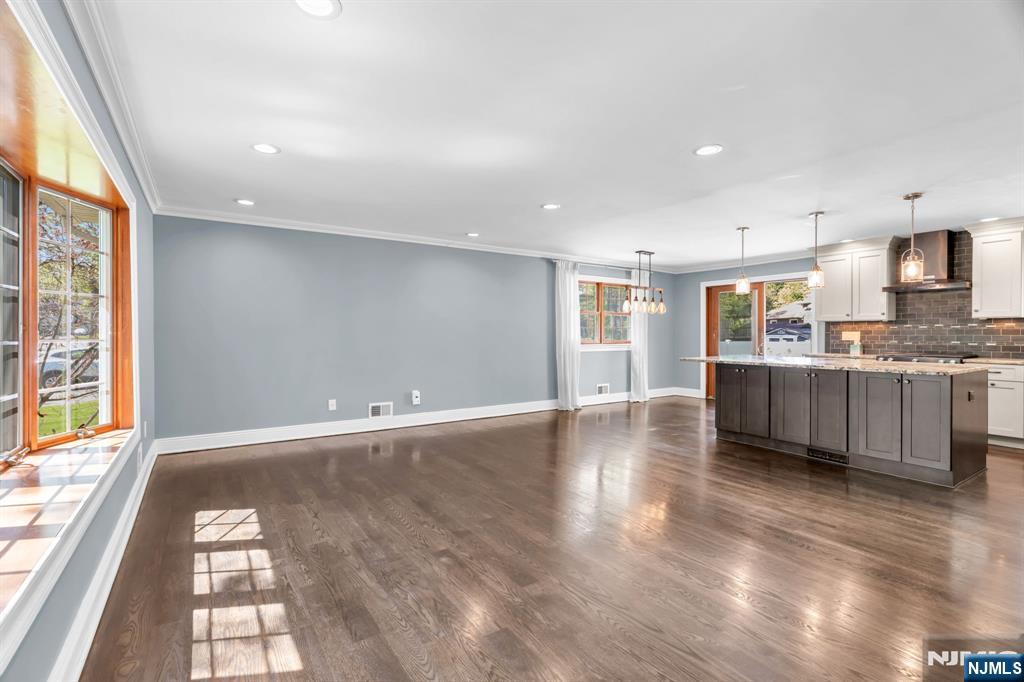 53 Smithfield Road Waldwick, NJ 07463 - Photo 16 of 48 a view of a kitchen with kitchen island a window wooden floor and stainless steel appliances