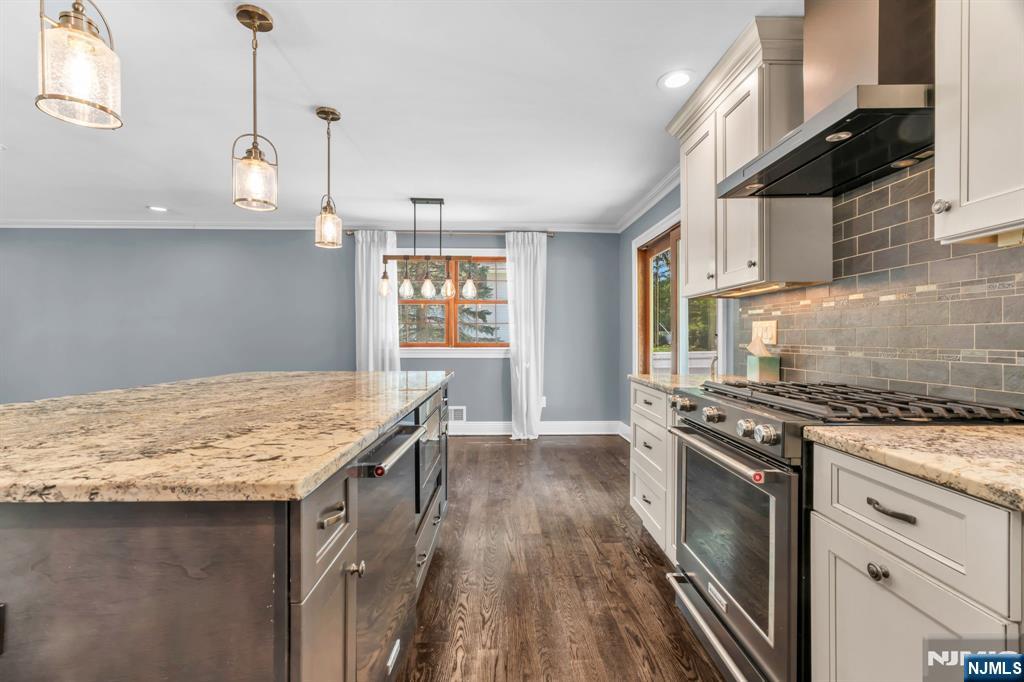 53 Smithfield Road Waldwick, NJ 07463 - Photo 21 of 48 a kitchen with granite countertop a stove a sink and a wooden floor