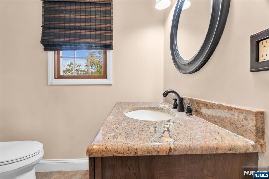 53 Smithfield Road Waldwick, NJ 07463 - Photo 26 of 48 a bathroom with a granite countertop sink and a mirror