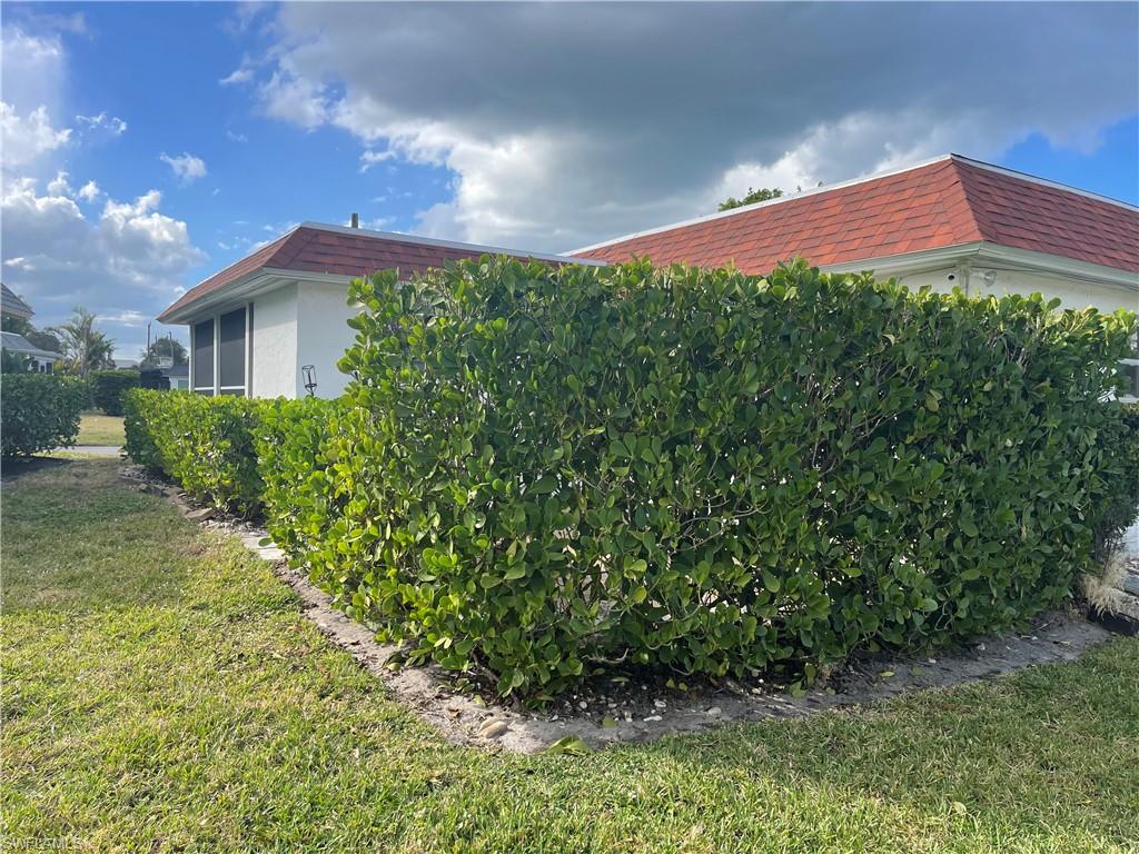 6 Hackney Lane, Unit A26 Naples, FL 34112 - Photo 4 of 24 View of property exterior featuring a yard