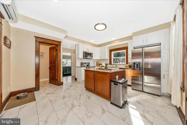 a kitchen with stainless steel appliances granite countertop a refrigerator and a sink