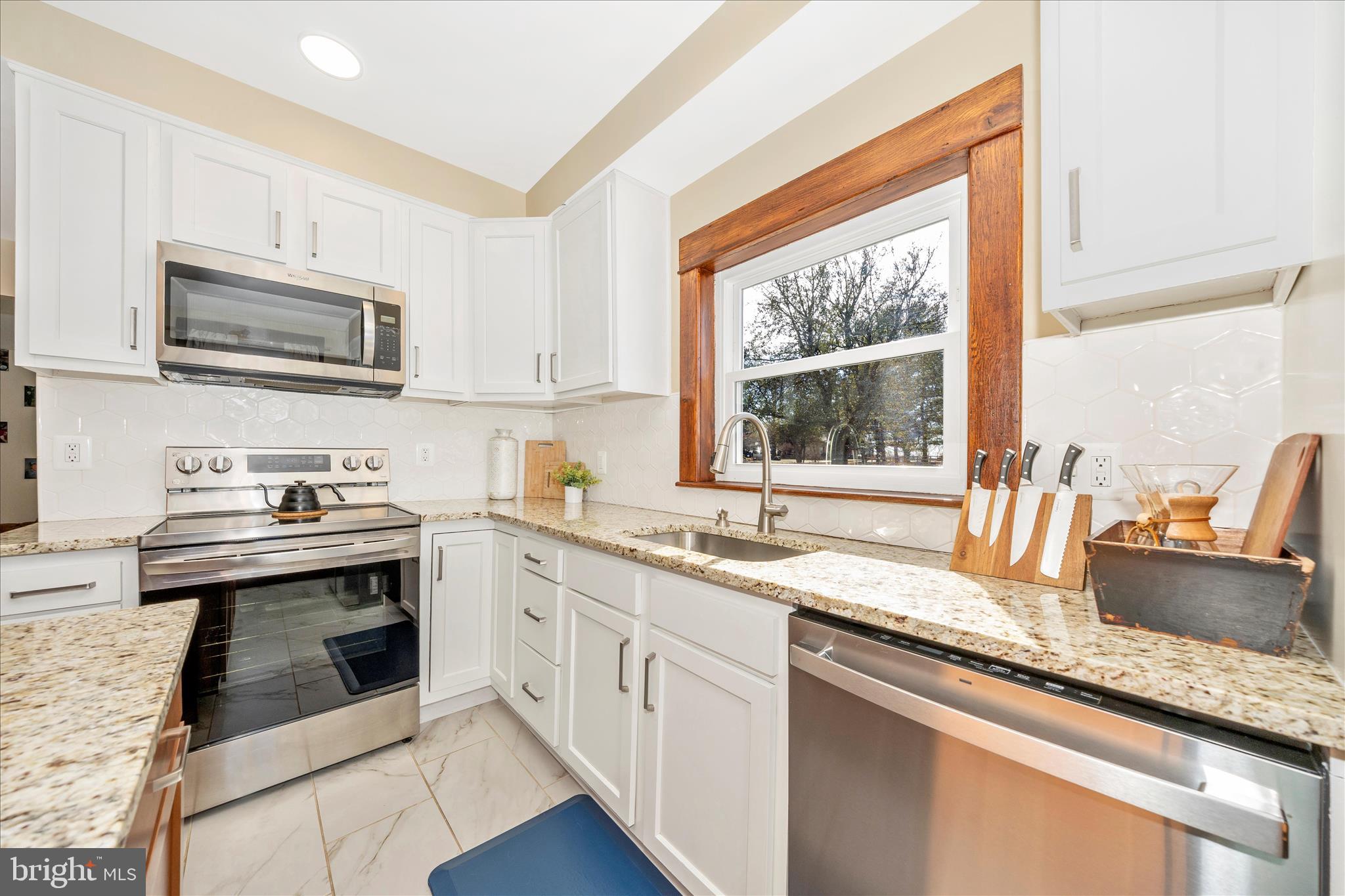 706 East Main Street Middletown, MD 21769 - Photo 17 of 63 a kitchen with granite countertop a sink cabinets stainless steel appliances and a window