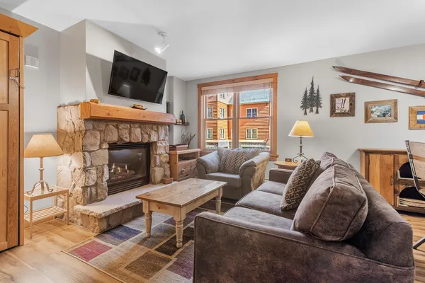 a living room with furniture a flat screen tv and a fireplace