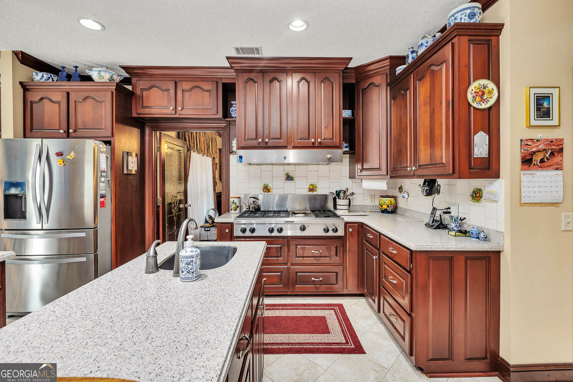 300 Elliott Road Waynesville, GA 31566 - Photo 46 of 89 a kitchen with stainless steel appliances granite countertop a refrigerator sink and cabinets