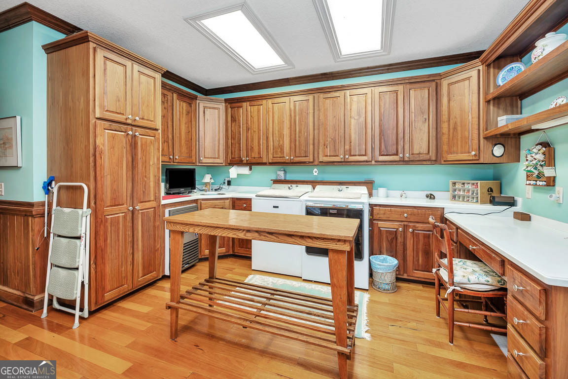 300 Elliott Road Waynesville, GA 31566 - Photo 52 of 89 a kitchen with stainless steel appliances a stove top oven a sink a dining table and chairs with wooden floor