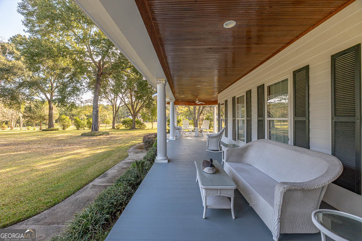 300 Elliott Road Waynesville, GA 31566 - Photo 8 of 89 a view of a patio with table and chairs and floor to ceiling window with wooden floor