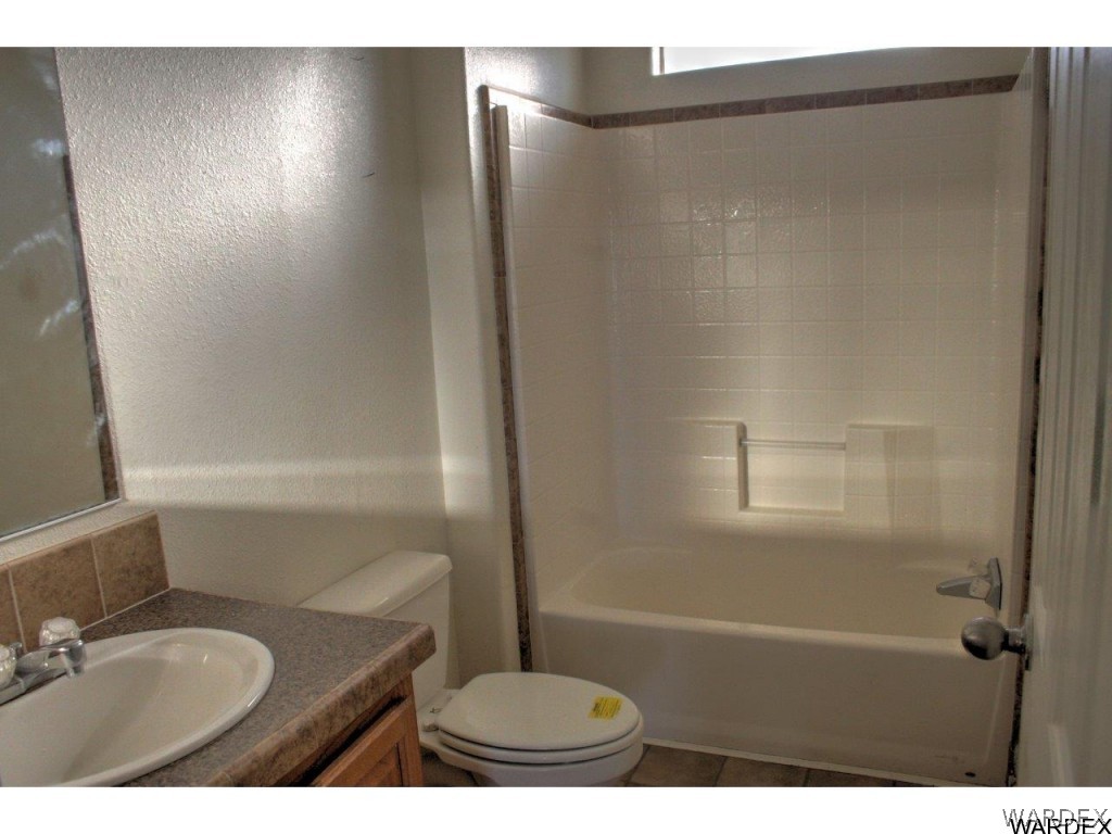 3969 Elfrida Road Golden Valley, AZ 86413 - Photo 11 of 29 a bathroom with a granite countertop sink toilet and shower