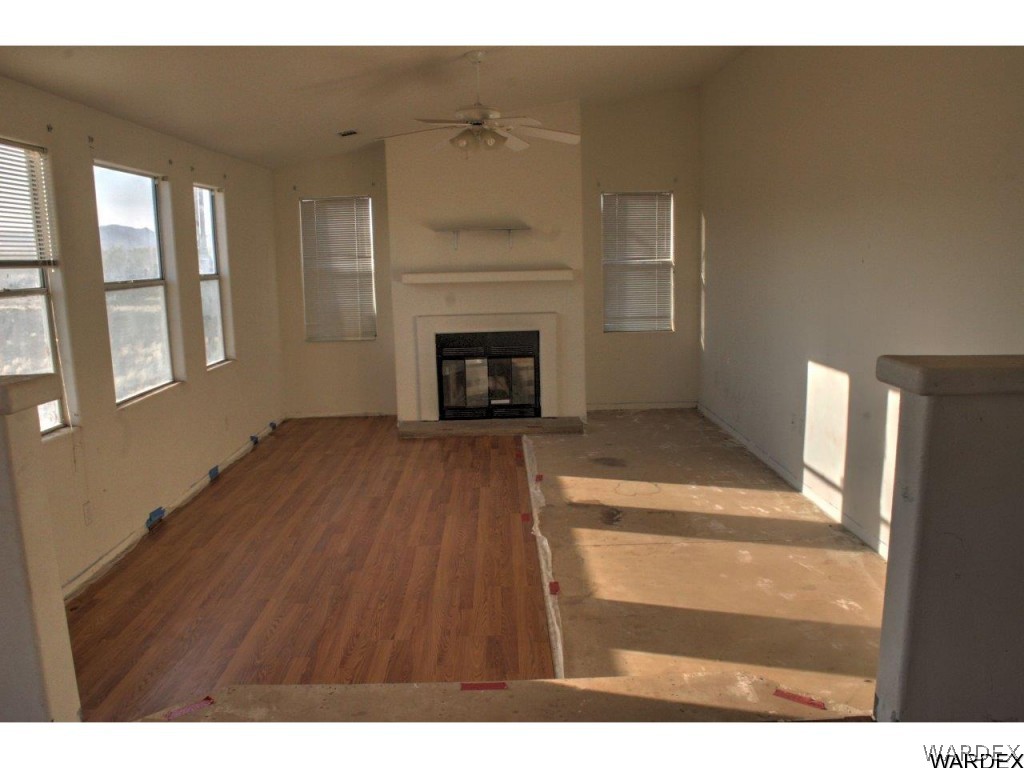 3969 Elfrida Road Golden Valley, AZ 86413 - Photo 5 of 29 a view of a livingroom with wooden floor a fireplace and windows