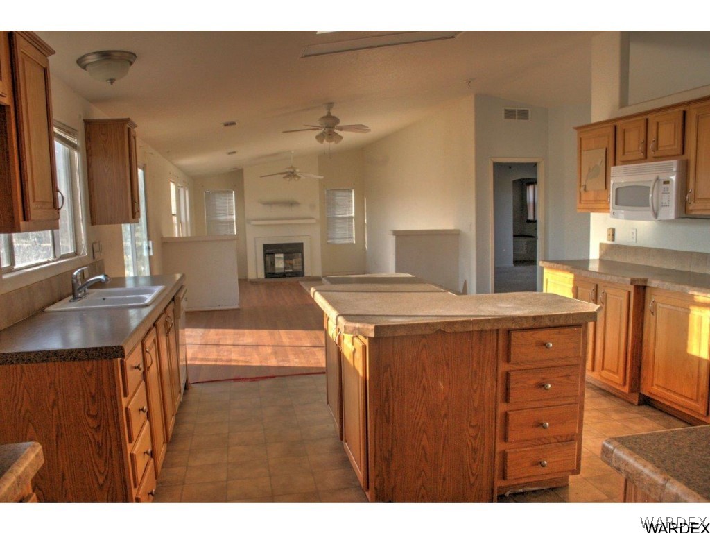 3969 Elfrida Road Golden Valley, AZ 86413 - Photo 8 of 29 a living room with kitchen island granite countertop wooden floor and a fireplace