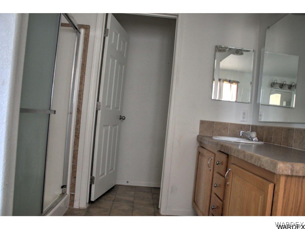 3969 Elfrida Road Golden Valley, AZ 86413 - Photo 9 of 29 a bathroom with a granite countertop sink and a mirror