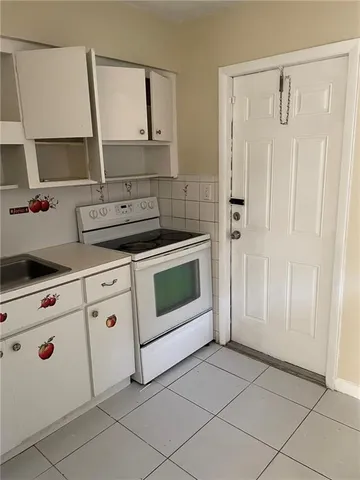 a kitchen with white cabinets and white appliances