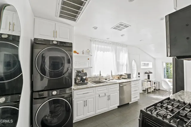 a view of a kitchen with sink washer and dryer