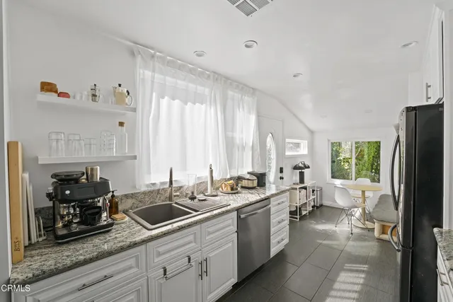 a kitchen with sink a refrigerator and cabinets