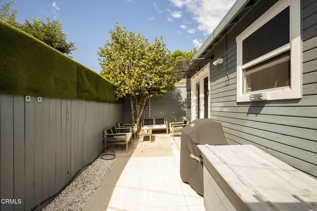 a view of a patio with table and chairs with wooden fence