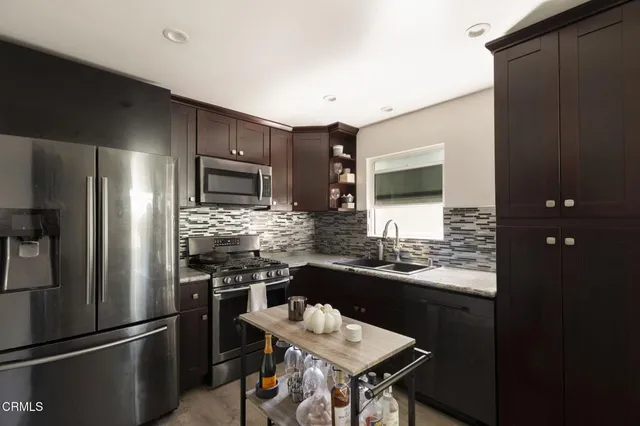 a kitchen with a refrigerator and a stove top oven