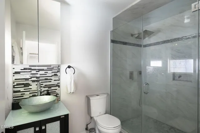 a bathroom with a sink a toilet a shower and a mirror