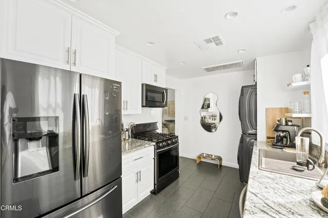 a kitchen with stainless steel appliances a refrigerator sink and stove