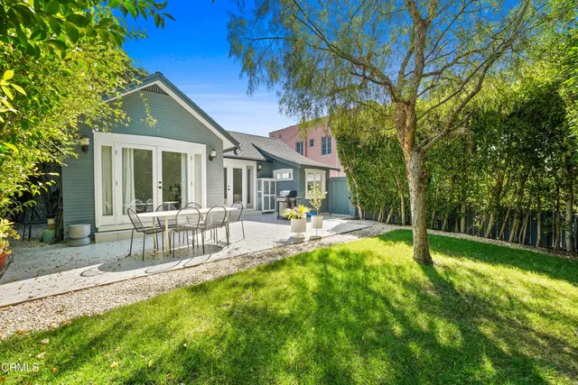 a view of a chair and table in backyard of the house