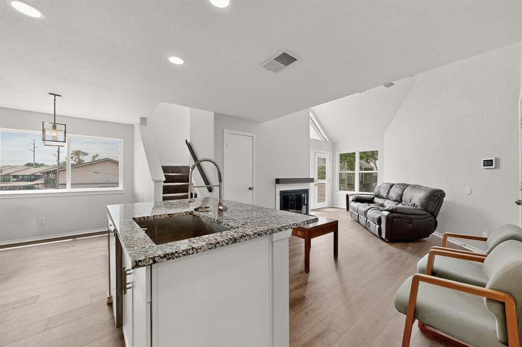 a kitchen that has a sink and a stove with the view of living room