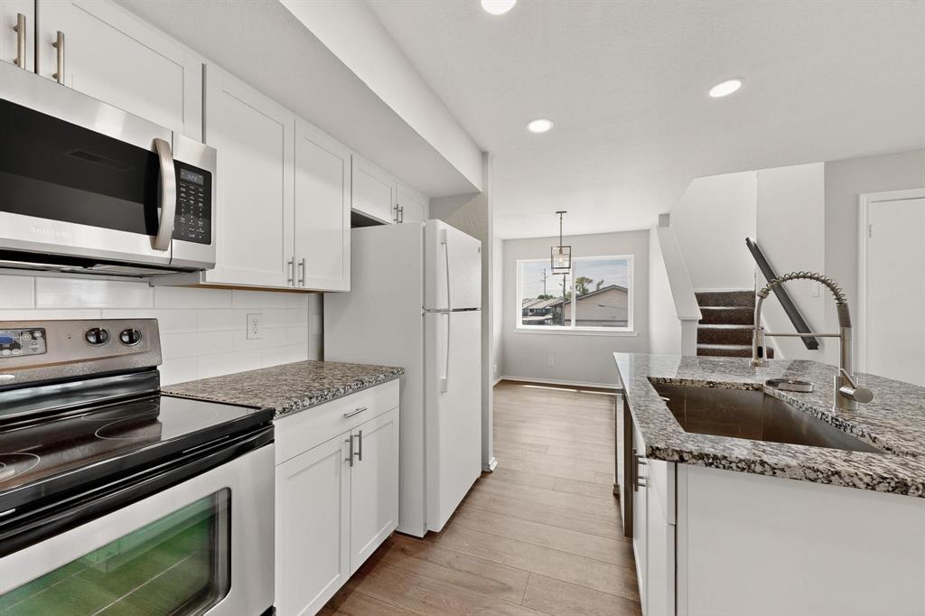 9809 Walnut Street, Unit E209 Dallas, TX 75243 - Photo 13 of 31 a kitchen with stainless steel appliances granite countertop a sink stove and refrigerator