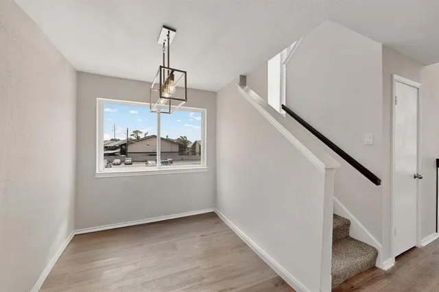a view of a hallway with wooden floor and staircase