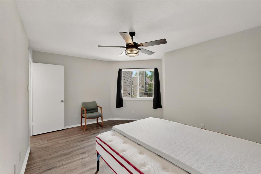 9809 Walnut Street, Unit E209 Dallas, TX 75243 - Photo 19 of 31 a workspace with chandelier fan and wooden floor
