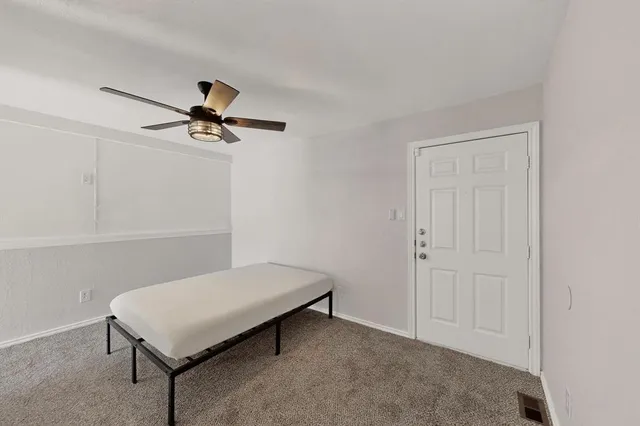 a living room with a bed and a ceiling fan