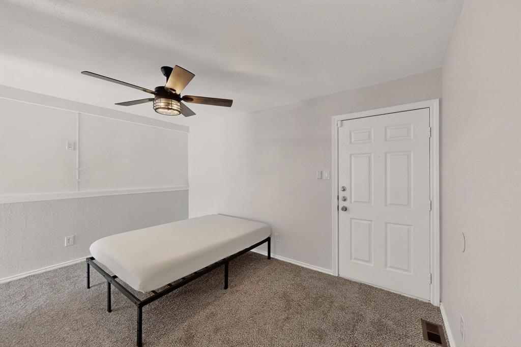 9809 Walnut Street, Unit E209 Dallas, TX 75243 - Photo 28 of 31 a living room with a bed and a ceiling fan