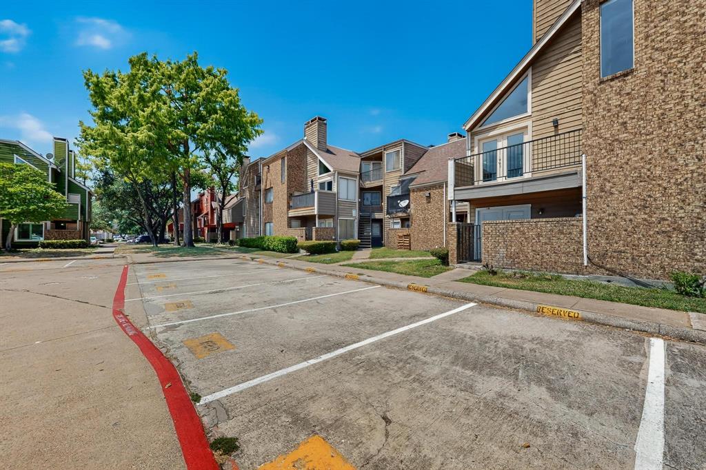 9809 Walnut Street, Unit E209 Dallas, TX 75243 - Photo 5 of 31 a front view of a house with a yard and garage
