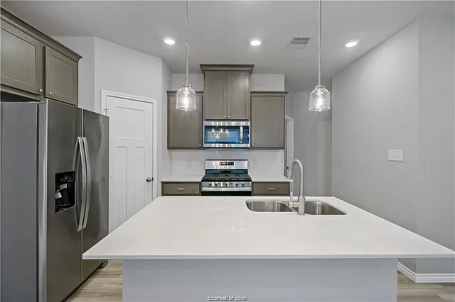 a kitchen with stainless steel appliances a refrigerator and a sink