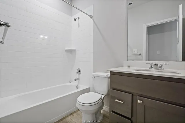 a bathroom with a sink toilet vanity and shower