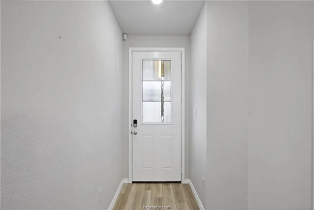a view of a room with wooden floor and mirror