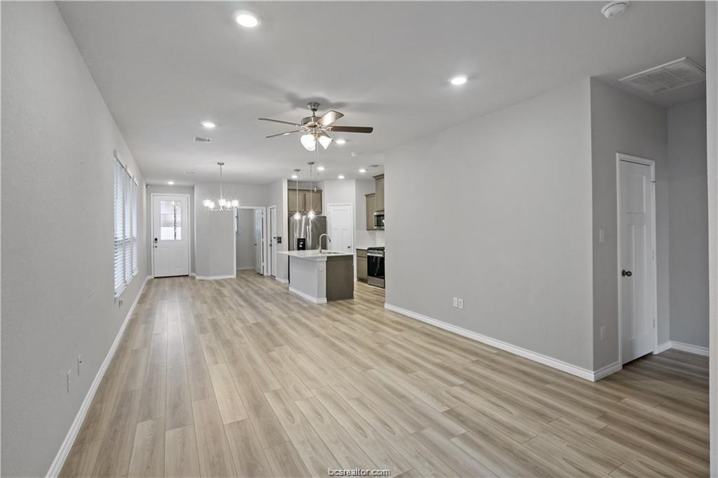 827 Mineral Wells Lane College Station, TX 77845 - Photo 7 of 23 a view of an empty room and kitchen view with wooden floor
