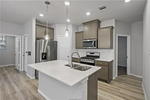 a kitchen with stainless steel appliances a refrigerator sink and stove