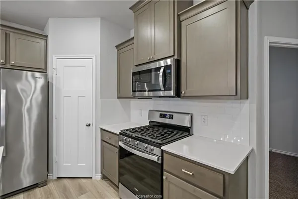 a kitchen with stainless steel appliances a refrigerator stove and microwave