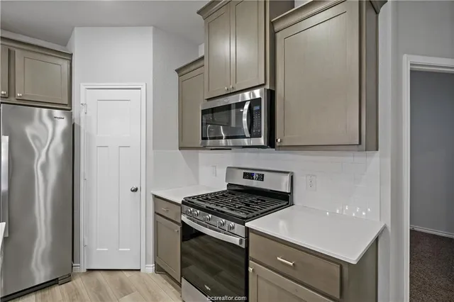 a kitchen with stainless steel appliances a refrigerator stove and microwave