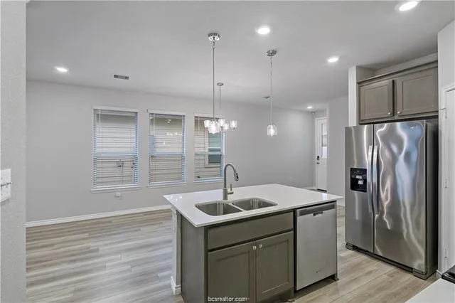 a kitchen with kitchen island a sink stainless steel appliances and cabinets