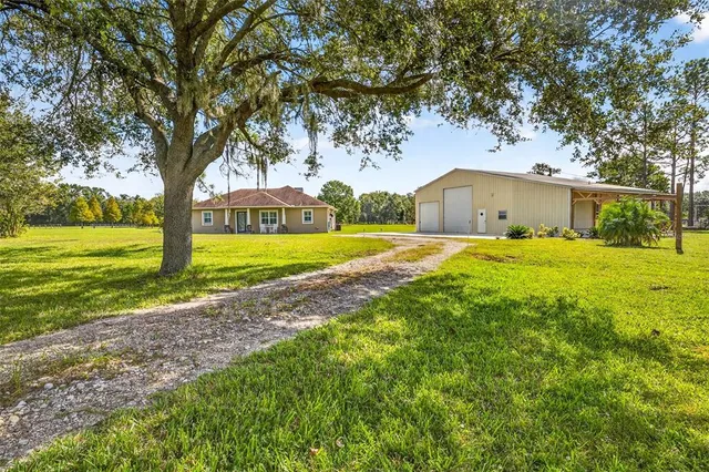 a view of a house with a swimming pool and a yard
