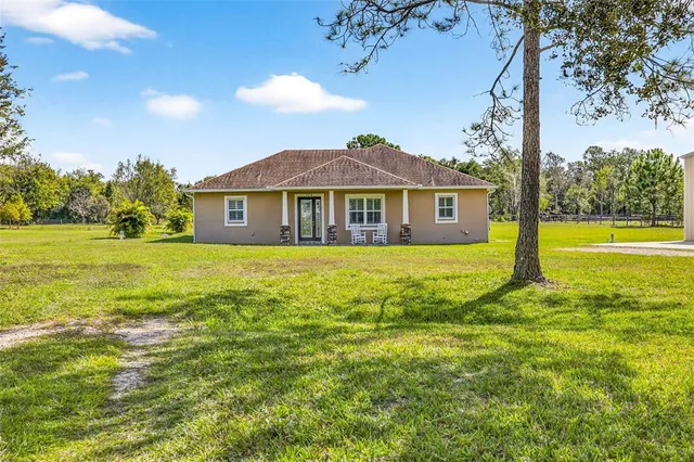 a view of a house with a yard and swimming pool