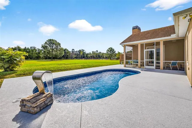 a view of yard with swimming pool and green space