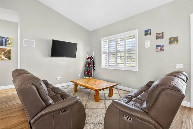 a large kitchen with stainless steel appliances granite countertop a stove top oven a sink dishwasher a dining table and chairs with wooden floor